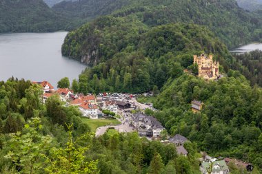 SCHWANGAU, GERMANY - 23 Mayıs 2024 Bu Alpsee Gölü, Schwangau ve Hohenschwangau Kalesi 'nin havadan görünüşü.
