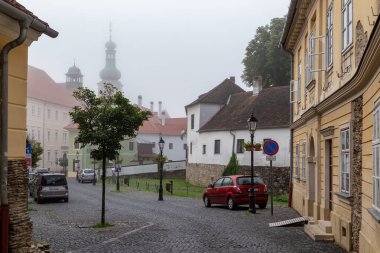 KOSZEG, HUNGARY - 18 Mayıs 2024: Bu ilkbahar sabahı sisli olan tarihi şehir merkezinin eski sokaklarından biri.