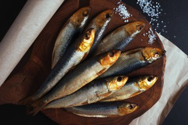Kahverengi tahta üzerinde füme sardalya. Bira için atıştırmalık.