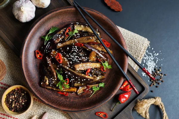中国茄子在一个深色盘子里的糖醋酱汁里 食品背景 图库图片