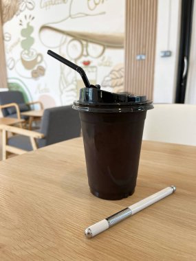 Kahve fincanı ve kalem iş yerindeki ahşap masada.