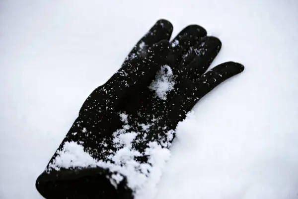 Karlı bir günde karla kaplı bir eldiven.