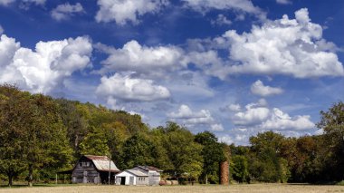 Sonbaharın başlarında bulutlu bir gökyüzünün altındaki eski bir çiftliğin manzarası
