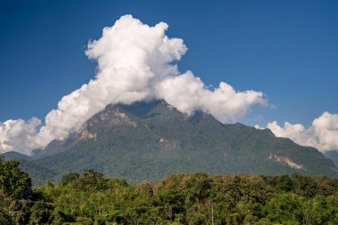 Tayland 'ın kuzeyindeki Doi Luang Chiang Dao' nun görkemli manzarası, Tayland 'ın üçüncü en yüksek dağı, güzel dramatik bulutlar ve renkli gökyüzü ile görülüyor.