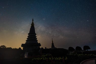 Chiang Mai, Tayland - 1 Mart 2023 - Doi Inthanon 'daki Phra Mahathat anıtlarında gece vakti Samanyolu' nun hareket etmesi ve ay ışığı altında yıldızlar