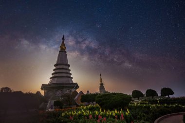 Chiang Mai, Tayland - 1 Mart 2023 - Doi Inthanon 'daki Phra Mahathat anıtlarında gece vakti Samanyolu' nun hareket etmesi ve ay ışığı altında yıldızlar