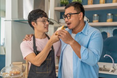 Mutlu, genç, aynı cinsiyetten bir çift, kaliteli zamanlarını birlikte yemek pişirerek ve konuşarak geçiriyor. LGBTQ konsepti.