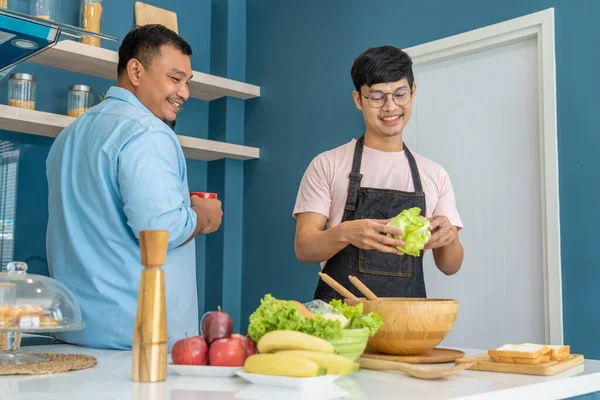 stock image Happy young same gender couple spending their quality time cooking and talking together in their home kitchen, LGBTQ concept