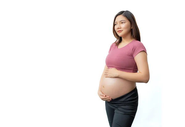 幸せな笑顔アジアの妊娠中の女性でフィットネス服身に着けています彼女の腹を誇りに思って白い背景 コピースペースのための部屋 — ストック写真