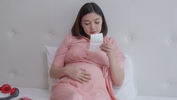 Mutlu Hamile Kadın Yatak Odasında Yatağında Yatarken Ultrason Resmine Bakıyor — Stok video