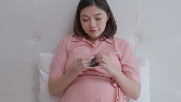 Mutlu Hamile Kadın Yatak Odasında Yatağında Yatarken Ultrason Resmine Bakıyor — Stok video