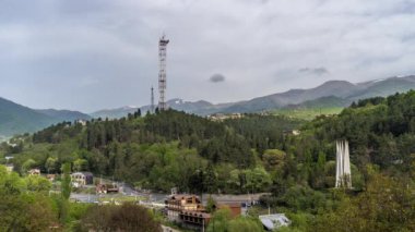Dilijan, Ermenistan - 7 Mayıs 2023 - Sovyetler Birliği 'nin 50 yıllık Dilijan Anıt Heykeli, ana yol ve güzel dağlar ve arka planda hareket eden bulutları gösteren Dilijan kentinin zamanaşımı manzarası