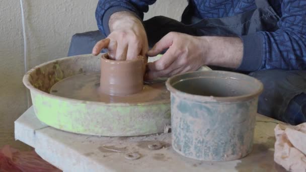 陶工の車輪を使って陶芸家の手を閉じてカップを作る — ストック動画