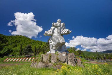 Dilijan, Ermenistan - 15 Mayıs 2023 - Dilijan, Ermenistan 'daki dağlara ve bulutlu gökyüzüne karşı hastane binalarının gece görüşü