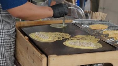 Chiang Mai, Tayland - 28 Mayıs 2023 - Crepe satıcısı Tayland 'ın Chiang Mai kentindeki yerel bir pazarda büyük ve küçük Tayland usulü krep üretiyor.