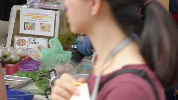 泰国清迈 2023年5月28日 年轻的女食品商从容器中取出蒸气腾腾的糯米 用香蕉叶包裹起来 在绿心农贸市场上卖给她的顾客 — 图库视频影像