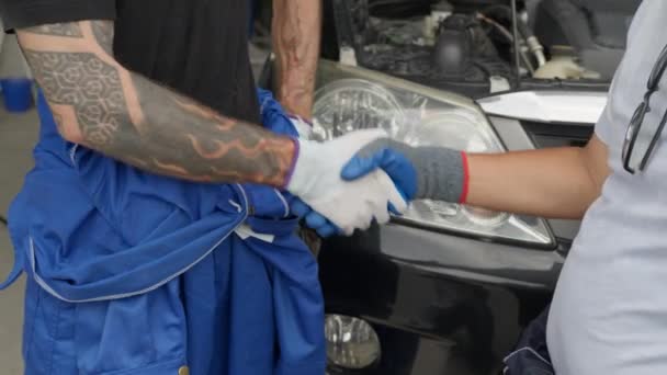 近2名机修工手握手套 在车前握手 — 图库视频影像