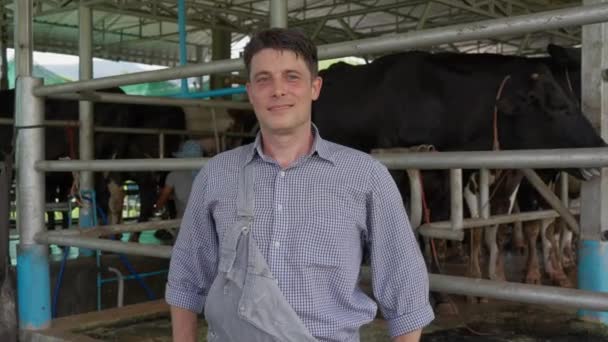 Een Gelukkige Mannelijke Melkveehouder Kruist Zijn Armen Glimlacht Naar Camera — Stockvideo