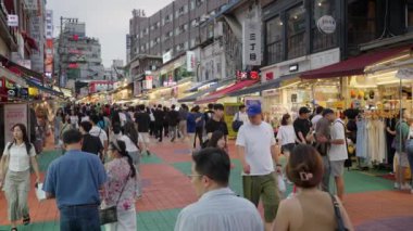 Seul, Güney Kore - 21 Ağustos 2023 - Güney Kore 'nin Seul kentindeki Hongdae Yürüyüş Caddesi' nde akşam saatlerinde yerel halk ve turistler dolaşıyor