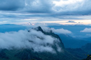 Gün doğarken Doi Luang Chiang Dao 'nun tepesinden güzel dağ sıralarında hareket eden beyaz bulutlara bakın.