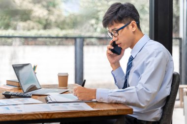 Genç arıcı ofisinde çalışırken telefonla konuşuyor.