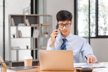 Genç arıcı ofisinde çalışırken telefonla konuşuyor.