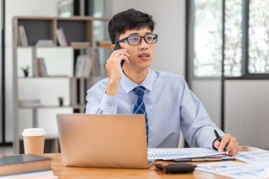 Genç arıcı ofisinde çalışırken telefonla konuşuyor.