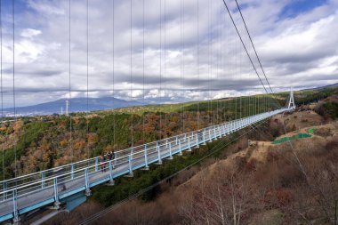 Mishima, Japonya - 12 Aralık 2024 - Japonya 'nın en uzun ayaklı asma köprüsü olan Mishima Skywalk Köprüsü manzarası, güneşli bir günde