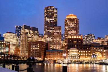 Boston, MA, ABD - 12 Şubat 2025 - Boston şehir merkezindeki gökdelenler soğuk bulutlu bir kış gecesinde Fan Pier Park 'tan görüldü