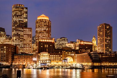Boston, MA, ABD - 12 Şubat 2025 - Boston şehir merkezindeki gökdelenler soğuk bulutlu bir kış gecesinde Fan Pier Park 'tan görüldü