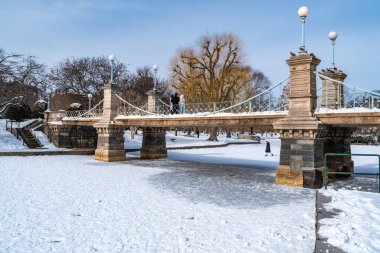 Boston, MA, ABD - 11 Şubat 2025 - Boston 'daki Public Garden Park' ta gölün üzerindeki halk bahçesi ayak köprüsü, MA kış karıyla kaplı