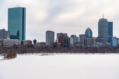 Boston, MA, ABD - 12 Şubat 2025 - Boston gökdelenlerinin ve kışın gökdelenlerin manzarası, buz ve karla kaplı Longfellow Köprüsü 'nden Charles Nehri' nin arkasında görüldü