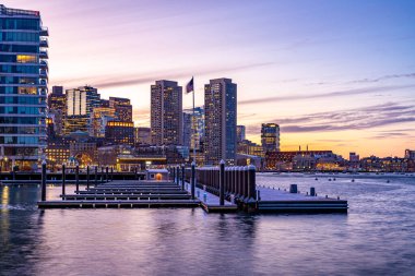 Boston, MA, ABD - 12 Şubat 2025 - Soğuk bulutlu bir kış akşamında Seaport Bölgesi 'nden Boston şehir merkezindeki gökdelenlerin görüntüsü