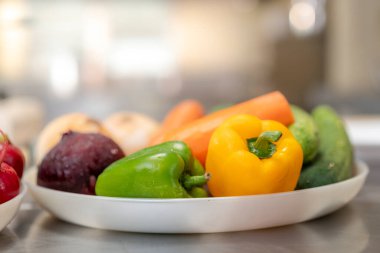 Mutfak masasındaki tabakta renkli sebzeler