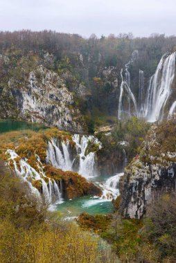 Hırvatistan 'ın Plitvice Ulusal Parkı' ndaki güzel Plitvice Gölleri şelalelerinin panoramik manzarası. Seyahat fotoğrafı. Dikey fotoğraf