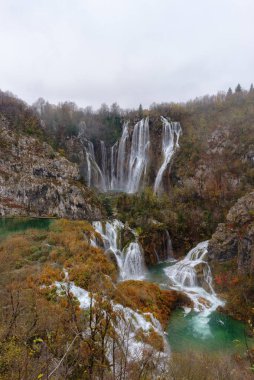 Sonbahar manzarası. Şelaleler, nehirler ve göller Hırvatistan 'da, Plitvice Gölleri Ulusal Parkı' nda. Gök mavisi yeşile, gri ya da mavi suya. Dikey fotoğraf