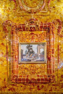 Puşkin, Rusya - 25 Eylül 2021 Kehribar Odası. Tsarskoye Selo 'da bir Rococo sarayı olan Catherine Sarayı' nda Barok tarzı detaylar. Salonun heykel ve yaldızlı oymaları ve süslemeleri. Dikey fotoğraf