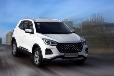 Chery white car on motion blurred background.