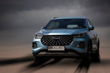 Bulanık bir arkaplanda vişne mavisi bir araba.