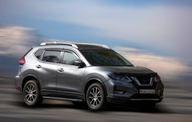 Geçmişi bulanık olan Nissan gümüş renkli araba.