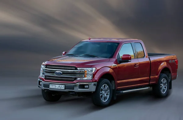 Hareket halinde Ford kırmızı pikap arka planda bulanık.