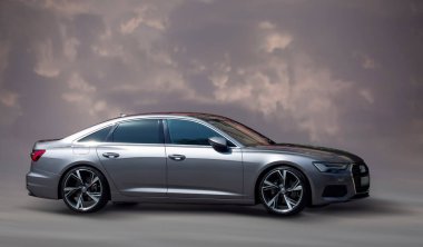 Arka planda bulanık hareket eden gümüş renkli Audi arabası.