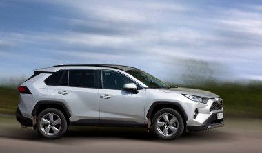 Hareket halindeki Toyota gri arabası arka planı bulanıklaştırdı.