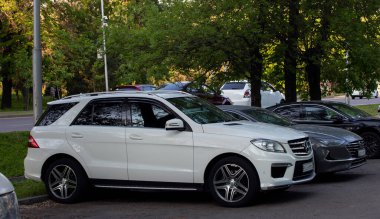 Mercedes Benz beyaz araba şehir caddesinde.