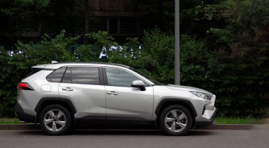 Ağaçların arkasındaki gümüş renkli Toyota arabası.