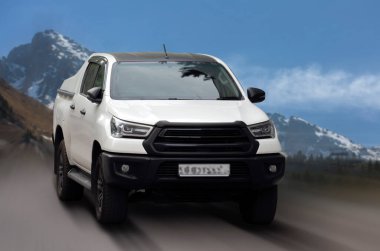 Toyota Hilux hareket bulanık arkaplanda beyaz bir araç.