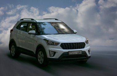 Hyundai beyaz arabası arka planda bulanık.