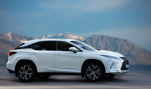 Белая машина Lexus на размытом фоне.