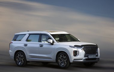 Bulanık bulutların arka planında Hyundai beyaz arabası.