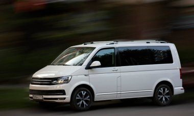 Hareket bulanık arkaplanda Volkswagen beyaz minibüsü.
